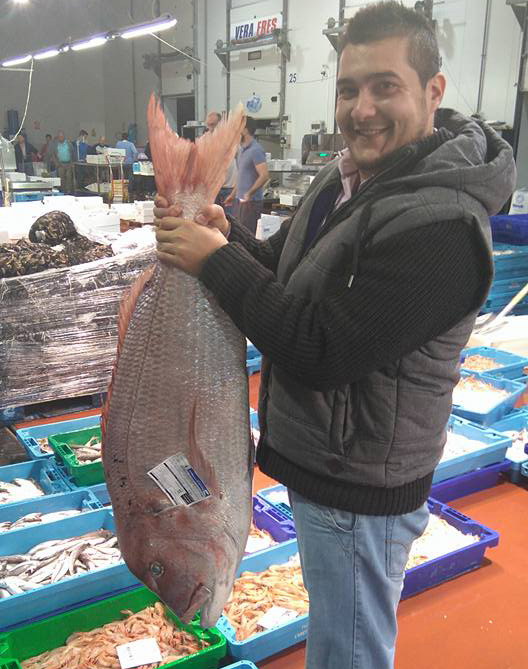 Salvador Mondejar sosteniendo pescado fresco para el restaurante